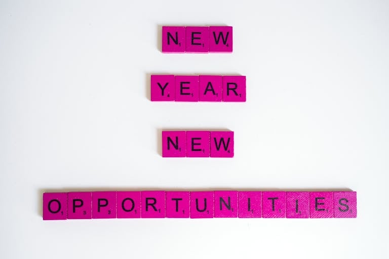 Pink scrabble tiles spelling 'New Year New Opportunities' on white background.